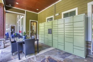 A patio with a table and chairs, surrounded by green mailboxes. Ideal for those seeking apartments for rent in The Woodlands TX.