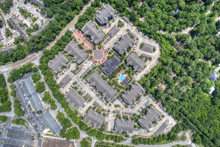 An aerial view of an apartment complex inm the woodland area of Houston TX nestled in the woodlands of TX.